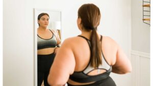 Overweight woman looks at herself in the mirror